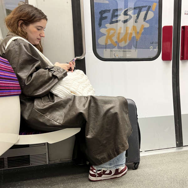 woman sitting in the Paris metro looking at her smartphone