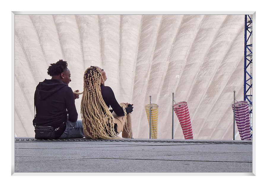 couple laughing under the Grande Arche, facing the CNIT roof